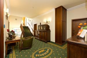 a lobby of a hotel with a desk and stairs at Waren Müritz Hotel Harmonie in Waren