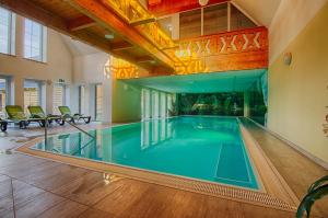 an indoor swimming pool in a building with a house at Seehotel Burg Spreewald in Byhleguhrer Kaupen