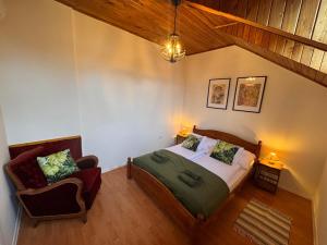 a bedroom with a bed and a chair at Keltafok Apartman, Balatonföldvár in Balatonföldvár