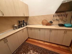 a kitchen with white cabinets and wooden floors at Vintage Stile in Ganja +13 photos
