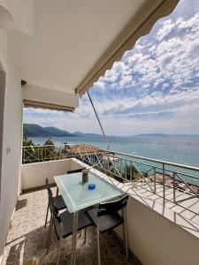 a table and chairs on a balcony with a view of the ocean at Qeparo Antonio Rooms in Qeparo