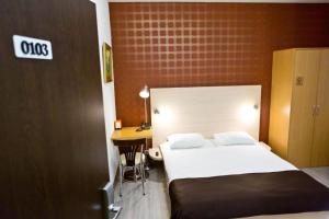 a hotel room with a bed and a desk at Hotel Olsi in Chişinău
