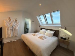 a bedroom with a bed with towels on it at Les Eclats d'Amour in Chargé