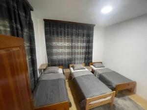 three beds in a room with a window at Hideout apartments Travnik in Travnik