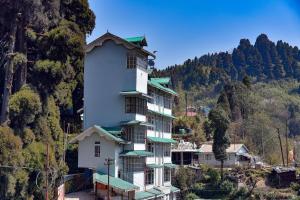 a large white building with green roofs on a mountain at Anutri Hotels & Resorts in Jāmb