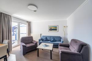 a living room with two chairs and a couch and a table at K & R Appartements Binz in Binz
