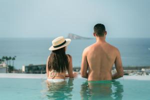 a man and a woman sitting in the water at Hotel Villa España in Benidorm