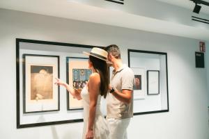 a man and woman looking at art in a museum at Hotel Villa España in Benidorm +71 photos