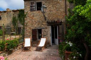 two chairs sitting in front of a building at Casa Torre Adults Only storia e relax a Fiorenzuola in Fiorenzuola di Focara