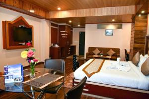 a hotel room with a bed and a desk with a computer at Anutri Hotels & Resorts in Jāmb