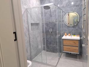 a bathroom with a shower with a sink and a mirror at Sea Breeze Nardaran open kitchen apartment in Nardaran +28 photos
