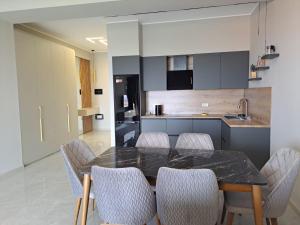 a kitchen with a dining room table and chairs at Sea Breeze Nardaran open kitchen apartment in Nardaran