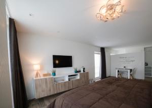 a bedroom with a bed and a flat screen tv at Q Studio in Herzele