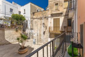 a balcony in an old building with a plant at Maison de Sisine in Capurso