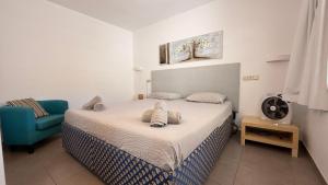 a bedroom with a bed and a blue chair at Casa di Luca EL VERGEL by luca properties gran canaria in Puerto Rico de Gran Canaria +28 photos