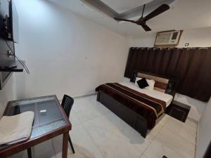 a bedroom with a bed and a desk with a ceiling fan at HOTEL ToWNHOUSE in New Delhi