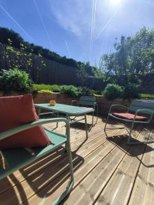 a patio with a table and chairs on a deck at Les Eclats d'Amour in Chargé