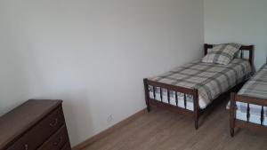a bedroom with two twin beds and a dresser at Maison cosy esprit campagne in Luçon