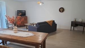a living room with a table and a couch at Maison cosy esprit campagne in Luçon