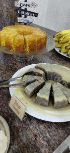 a plate of food on a table with a cake at Pousada Costa do Sol in Aracruz