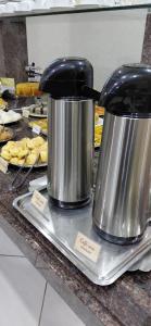 two coffee pots sitting on top of a counter at Pousada Costa do Sol in Aracruz