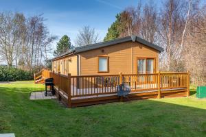 a large wooden cabin with a large deck at Rivendale Lodge in Port Seton