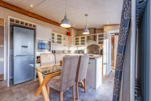 a kitchen with a glass table and chairs at Rivendale Lodge in Port Seton