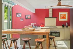 a kitchen with red walls and a wooden table at Villa Marea - Exceptional Beachfront Sanctuary in Tamarin