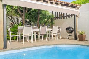 a patio with a table and chairs next to a pool at Villa Marea - Exceptional Beachfront Sanctuary in Tamarin