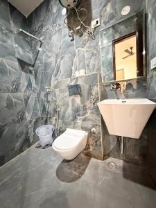 a bathroom with a toilet and a sink at Hotel The Grand Villa by Signature Stayz Near International Airport in New Delhi