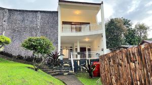 a house with a fence in front of it at Villa Kay Height in Kopo 2