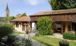 a small house with a clock tower in the background at Entre seine et canal in Méry-sur-Seine
