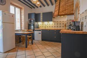 a kitchen with black cabinets and a table and a refrigerator at Entre seine et canal in Méry-sur-Seine