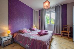 a bedroom with purple walls and a bed with pillows at Entre seine et canal in Méry-sur-Seine