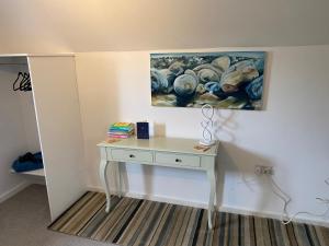 a desk in a room with a painting on the wall at The Threshing Barn Loft in Pont-y-Berem +3 photos