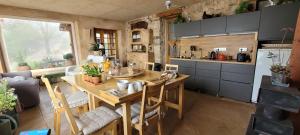 a kitchen with a wooden table with chairs and a kitchen with a counter at Chambre des pierres, Cadre Magnifique au Cœur du Verdon in Castellane +16 photos
