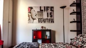 トリノにあるCit Ma Bonのベッドルーム1室(ベッド1台付)が備わります。壁に絵が飾られています。
