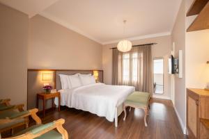 a bedroom with a large white bed and a chair at Viento Alacati Hotel in Alaçatı +135 photos