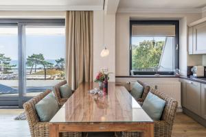 a dining room with a wooden table and chairs at Herzbergs Ferienwohnung Meersehen in Scharbeutz