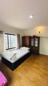 a bedroom with a large bed and wooden floors at Pharping StayInn in Pharping