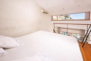 a white bed in a room with a window at Le Mistral par Dodo-a-Cassis in Cassis