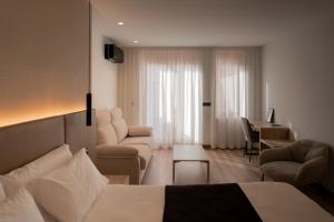 a hotel room with a bed and a living room at L'Agora Rooms in Bocairent