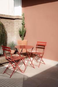 two red chairs and a table and a cactus at L'Agora Rooms in Bocairent