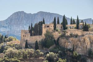 an old castle on a mountain with mountains in the background at Le Mistral par Dodo-a-Cassis in Cassis