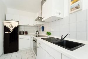 a kitchen with a black refrigerator and white cabinets at Bargmöhl 7 Heber in Fehmarn