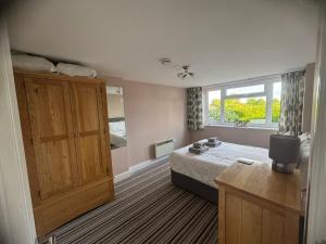 a bedroom with a bed and a large window at Greenbanks 2 Damerham Self Catering in Damerham