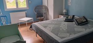 ein Schlafzimmer mit einem großen Bett und einem Stuhl in der Unterkunft Douce vallee in Vaux-lès-Saint-Claude