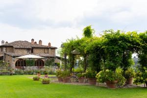 a garden with potted plants in front of a house at Capannelle Wine Resort in Gaiole in Chianti