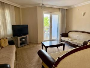 a living room with a couch and a tv at Dove Apart Hotel in Fethiye