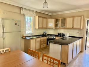 a kitchen with a refrigerator and a table with chairs at Dove Apart Hotel in Fethiye